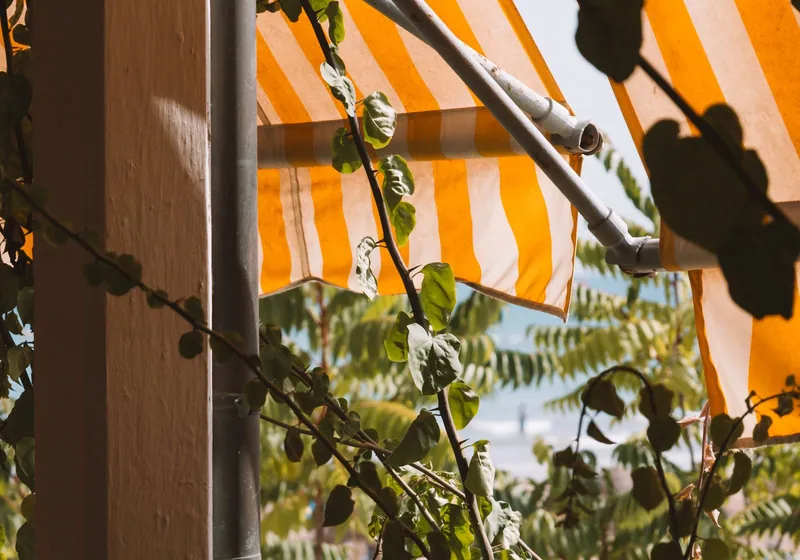 Uitgeklapt uitvalscherm dat schaduw geeft op een zonnig terras
